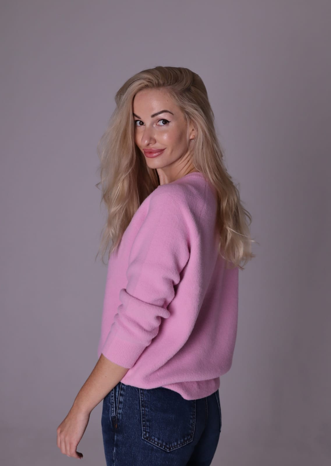 Frau in rosa Pullover und Jeans.